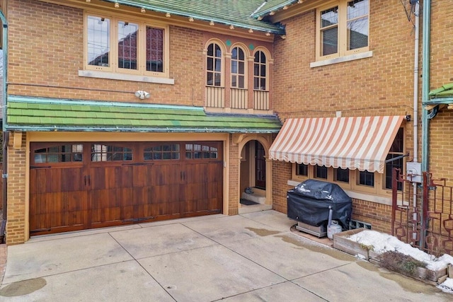 view of front of home with brick siding, driveway, and an attached garage