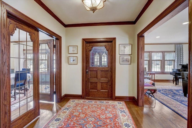 entrance foyer with ornamental molding, french doors, wood finished floors, and baseboards