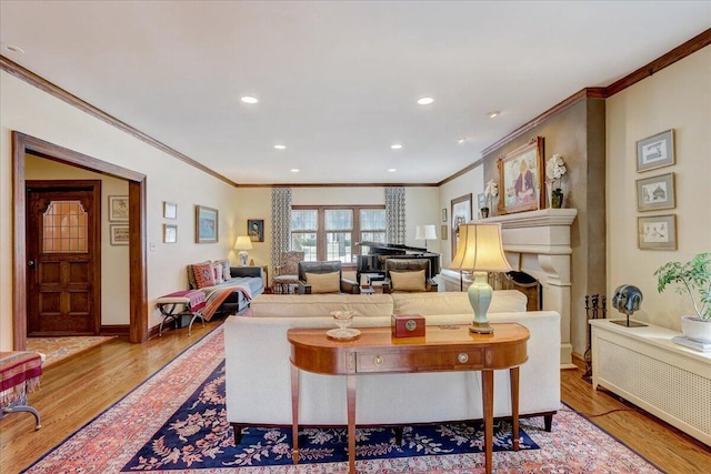 living room featuring a fireplace, baseboards, wood finished floors, and recessed lighting