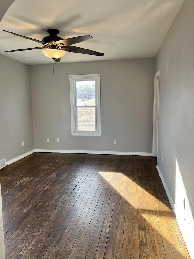 empty room featuring visible vents, baseboards, ceiling fan, and hardwood / wood-style floors