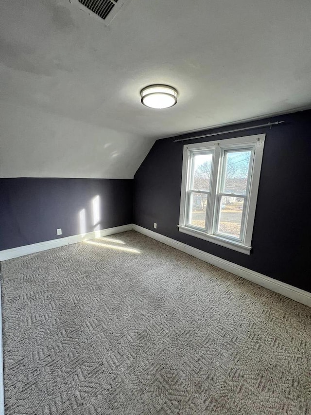 bonus room with baseboards, lofted ceiling, and carpet flooring