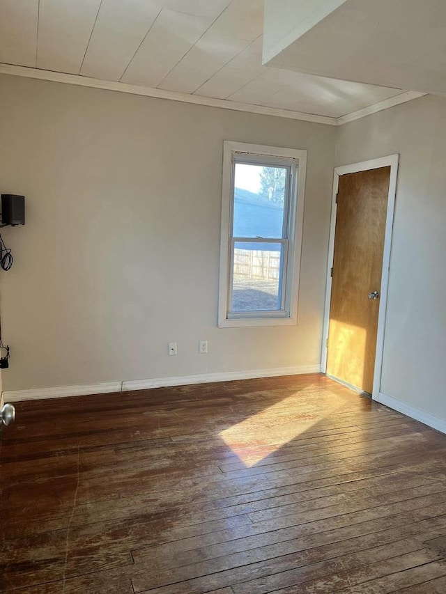 unfurnished room featuring crown molding, baseboards, and wood-type flooring