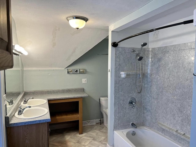 bathroom with toilet, shower / tub combination, lofted ceiling, double vanity, and a sink