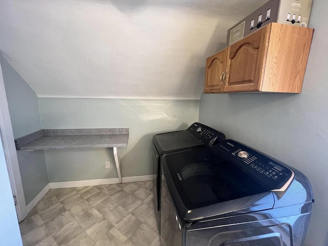 clothes washing area with washing machine and clothes dryer, cabinet space, and baseboards