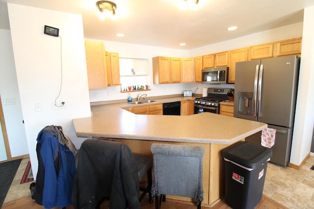 kitchen featuring stainless steel appliances, a peninsula, a sink, light countertops, and light brown cabinetry