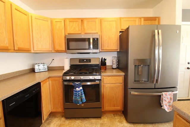 kitchen with light brown cabinets, appliances with stainless steel finishes, and light countertops