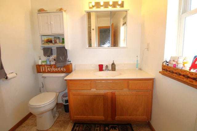 bathroom featuring baseboards, vanity, and toilet