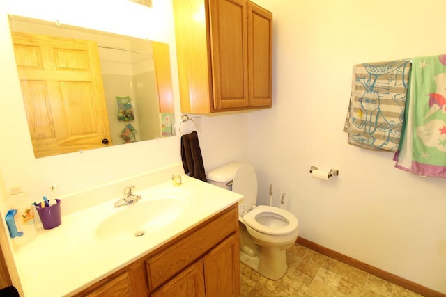 bathroom with toilet, baseboards, and vanity