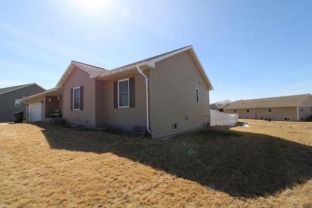 view of property exterior with a yard and an attached garage