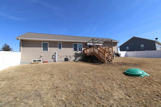 rear view of property with a fenced backyard, stairs, a deck, and a lawn