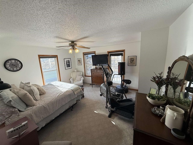 bedroom with light carpet, a textured ceiling, multiple windows, and a ceiling fan