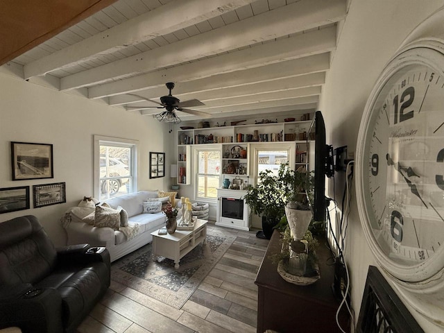 living room with beam ceiling, a fireplace, ceiling fan, wood finished floors, and wooden ceiling