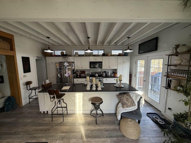 kitchen featuring dark wood-style floors, dark countertops, appliances with stainless steel finishes, white cabinetry, and beamed ceiling