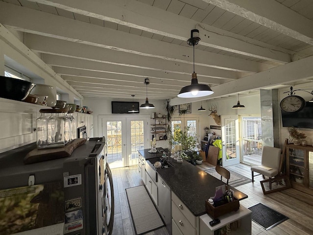 kitchen with pendant lighting, french doors, beam ceiling, white cabinetry, and wood finished floors