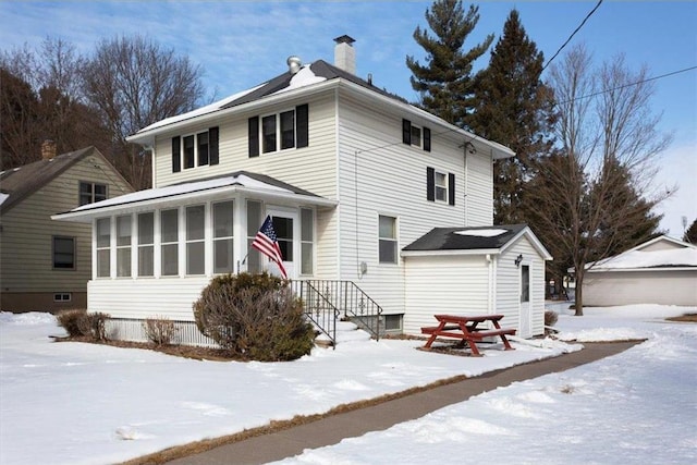 view of front of house featuring a sunroom and a chimney