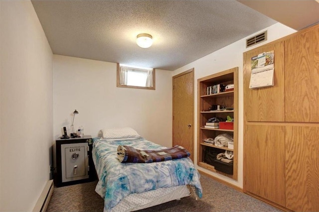 bedroom featuring carpet, visible vents, a closet, a textured ceiling, and a baseboard heating unit