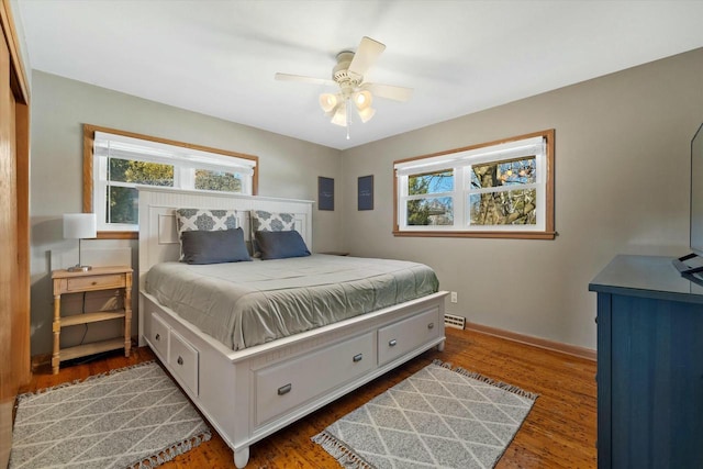 bedroom featuring baseboards, multiple windows, and wood finished floors