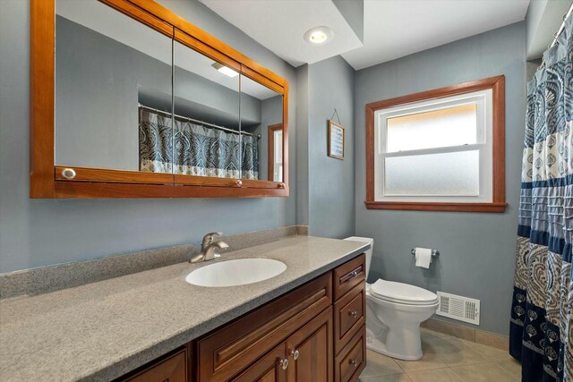 bathroom featuring tile patterned flooring, visible vents, baseboards, toilet, and vanity