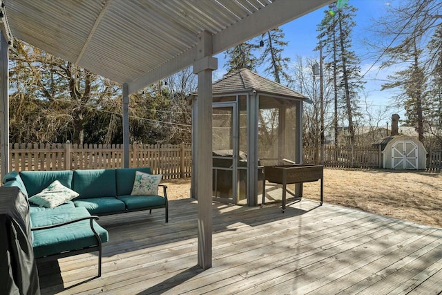 deck with an outbuilding, a storage shed, a fenced backyard, and outdoor lounge area