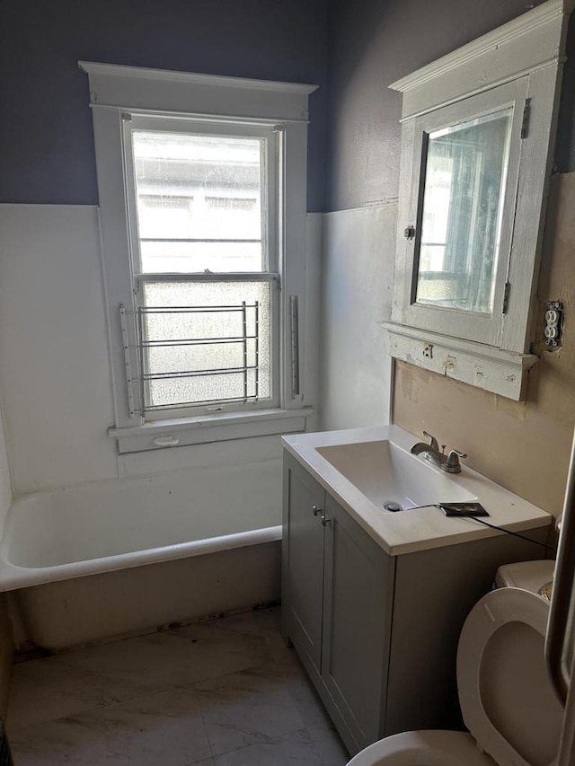 full bath with marble finish floor, vanity, toilet, and a bath