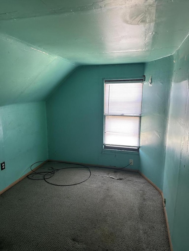 bonus room with lofted ceiling, carpet flooring, and baseboards