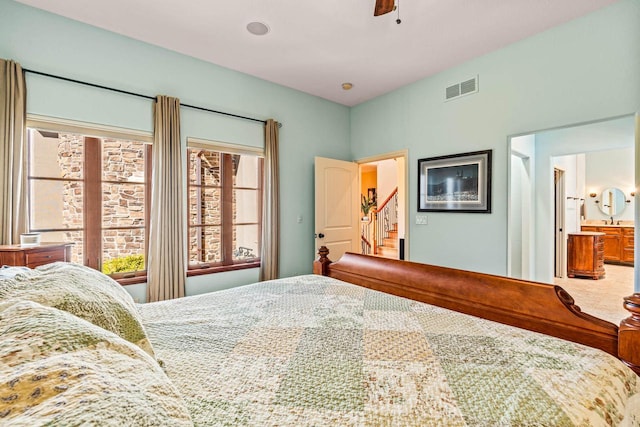 bedroom featuring ensuite bath, visible vents, and ceiling fan