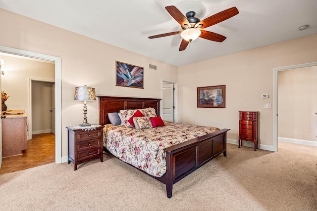 bedroom featuring baseboards, light carpet, visible vents, and ceiling fan