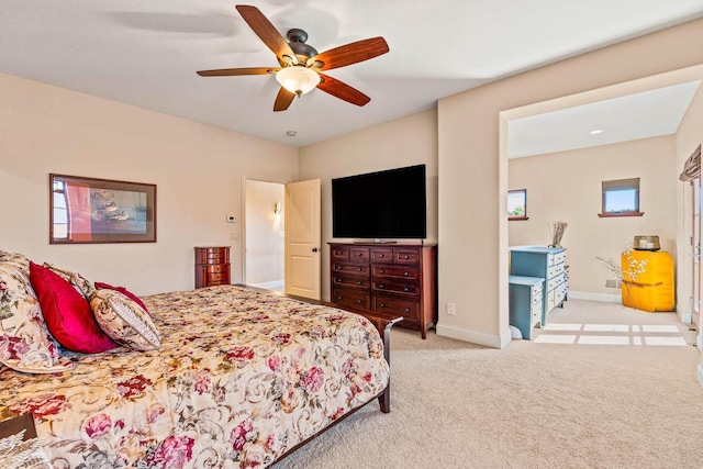 bedroom with light carpet, a ceiling fan, and baseboards