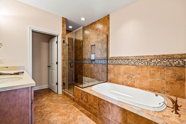 full bathroom with a shower stall, baseboards, a garden tub, and a sink