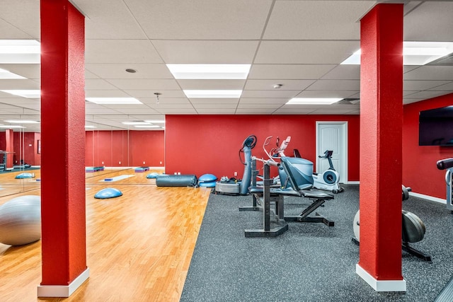 workout area with baseboards and a paneled ceiling