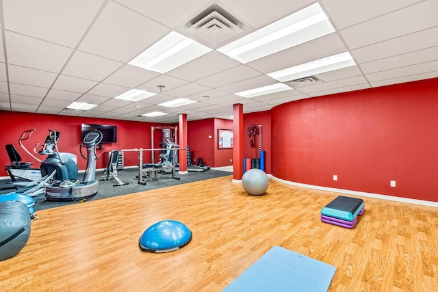 workout area featuring baseboards, visible vents, and a drop ceiling