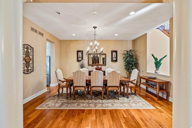 dining area with visible vents, baseboards, and wood finished floors