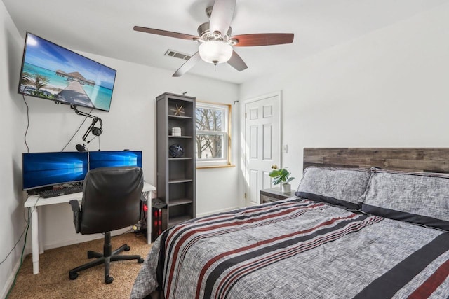 carpeted bedroom featuring a ceiling fan, visible vents, and baseboards