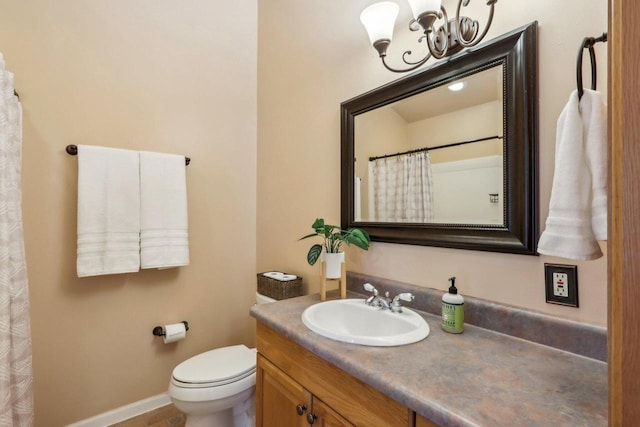 full bathroom featuring toilet, baseboards, a notable chandelier, and vanity