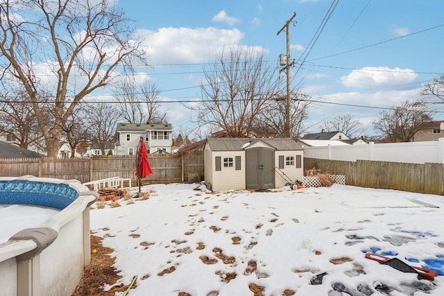 view of yard featuring a storage shed, a fenced backyard, and an outdoor structure