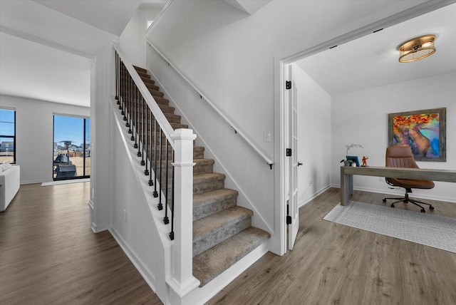 stairway with baseboards and wood finished floors