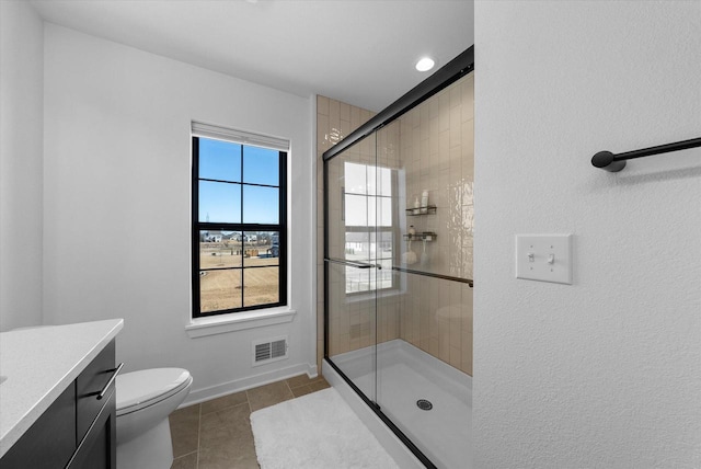 bathroom featuring visible vents, a shower stall, vanity, baseboards, and tile patterned floors