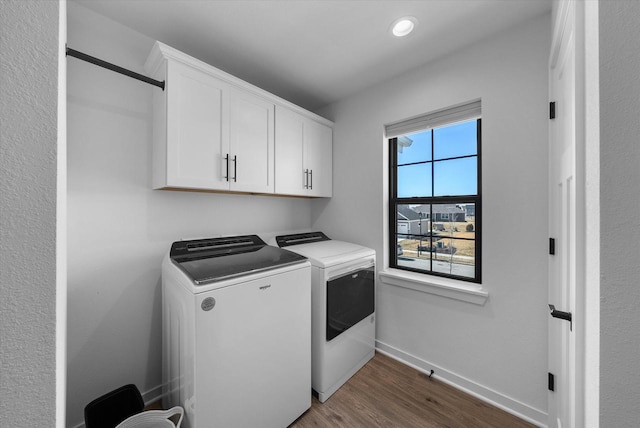 clothes washing area with recessed lighting, baseboards, washer and dryer, cabinet space, and dark wood finished floors