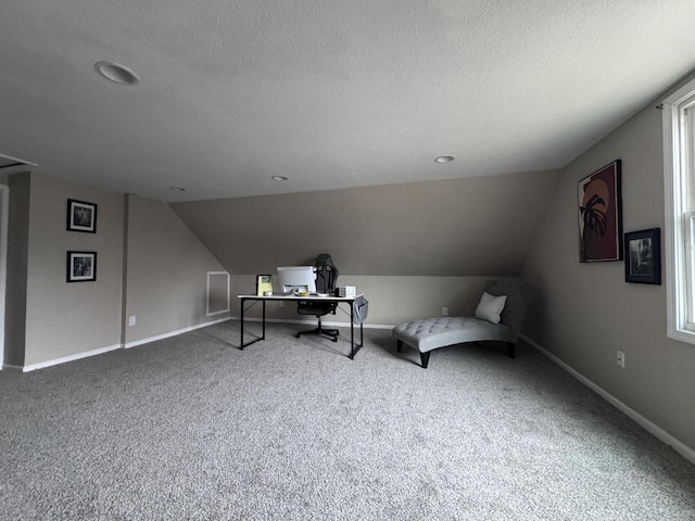 carpeted home office featuring lofted ceiling, baseboards, and a textured ceiling