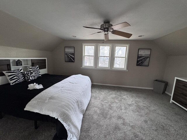 carpeted bedroom with ceiling fan, baseboards, and vaulted ceiling