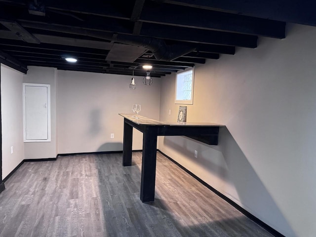 basement with baseboards and wood finished floors