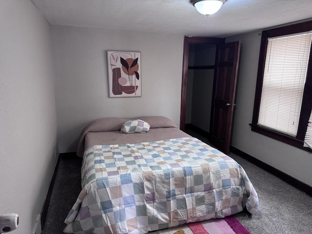 bedroom featuring carpet floors, baseboards, and a textured ceiling