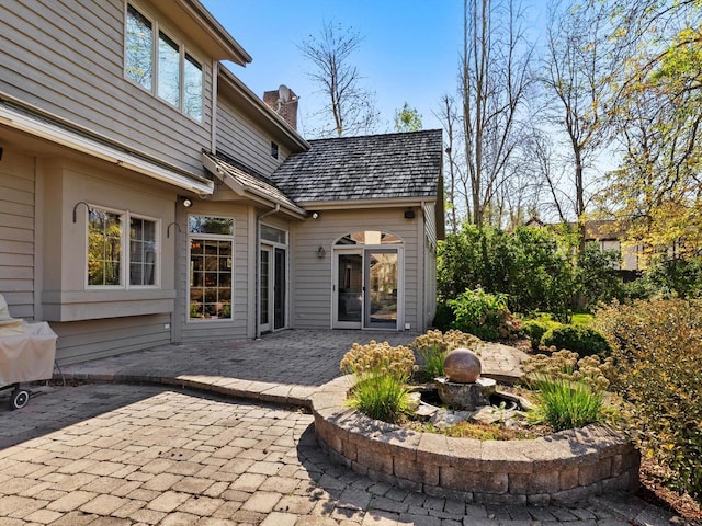 back of house with a chimney and a patio area