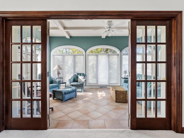 sunroom featuring ceiling fan and beamed ceiling