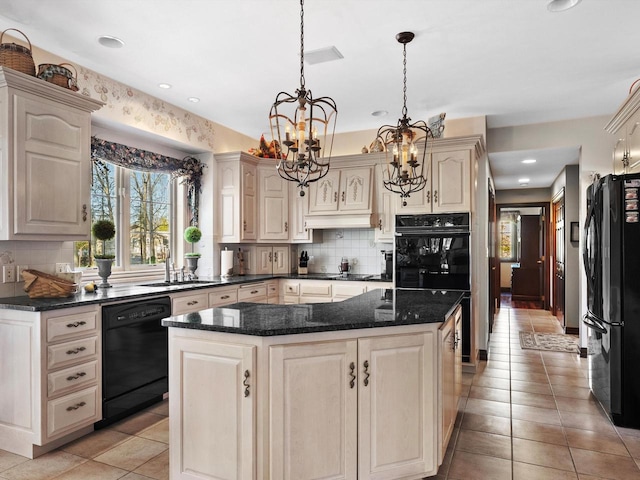 kitchen featuring tasteful backsplash, a center island, a sink, black appliances, and a notable chandelier