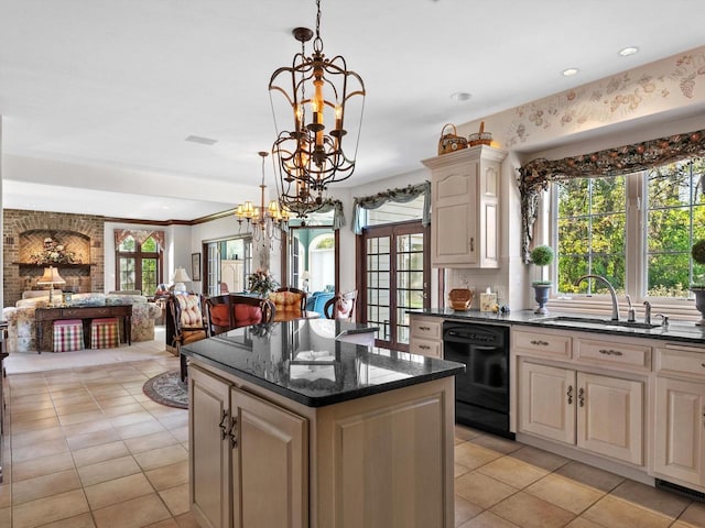 kitchen with dishwasher, cream cabinetry, a sink, and an inviting chandelier