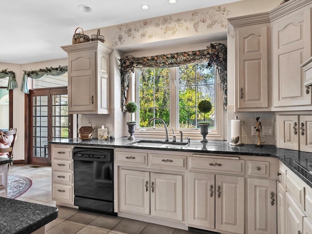 kitchen with decorative backsplash, light tile patterned flooring, a sink, dark stone countertops, and dishwasher