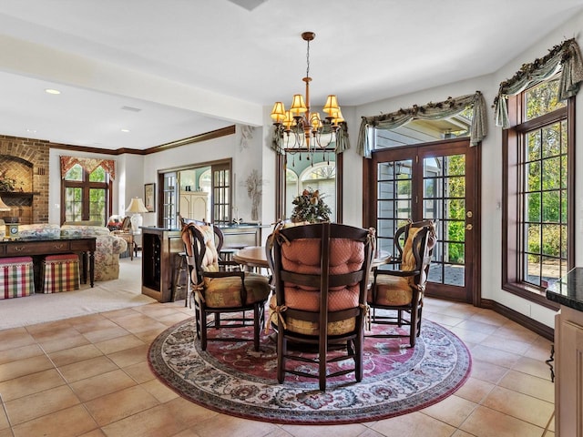 dining room featuring baseboards, a chandelier, a wealth of natural light, and light tile patterned flooring