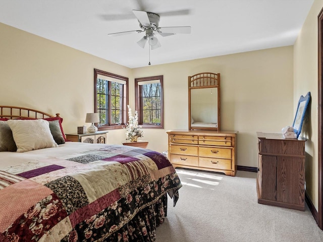 carpeted bedroom with ceiling fan and baseboards