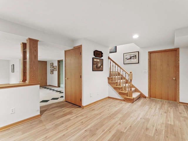 spare room with light wood-style floors, stairs, baseboards, and recessed lighting